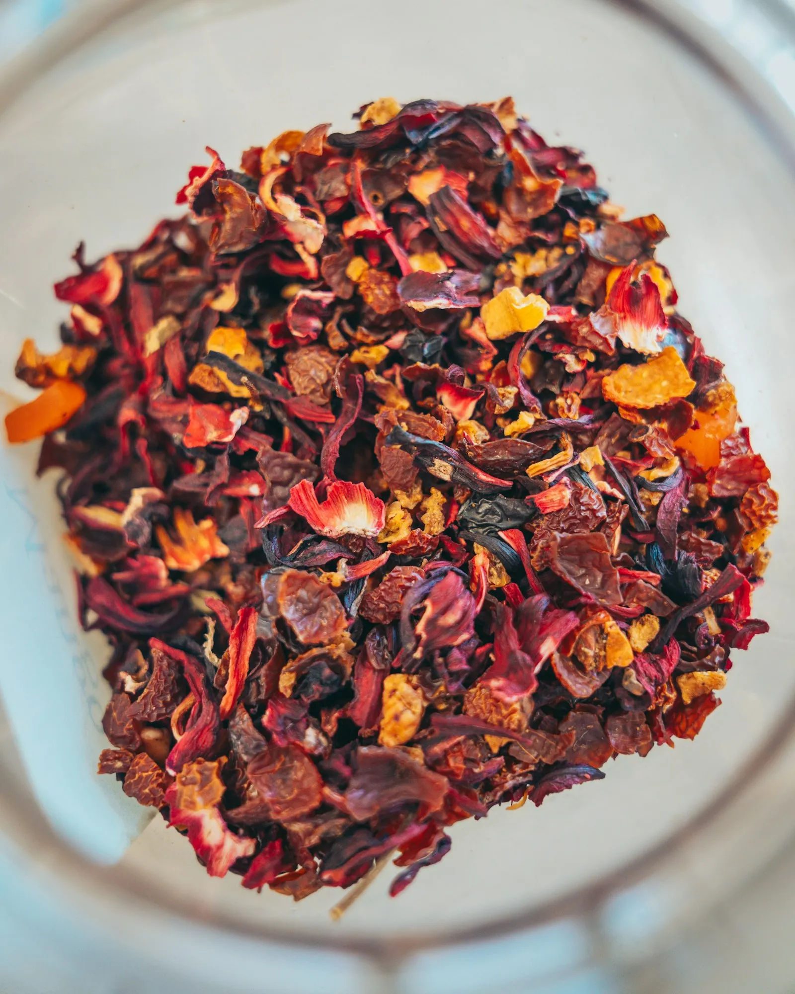 A pile of dried hibiscus flowers in a glass bowl